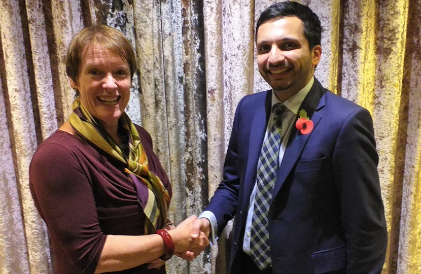 Saqib being congratulated by Dame Caroline Spelman