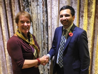 Saqib being congratulated by Dame Caroline Spelman